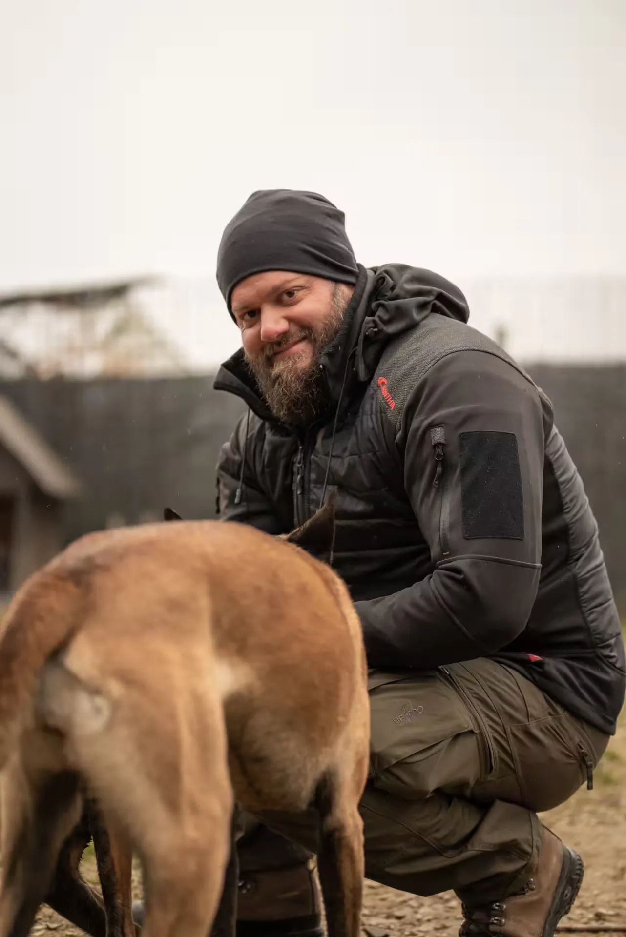 Georg Resch kniet lächelnd neben einem Hund auf dem Vereinsgelände